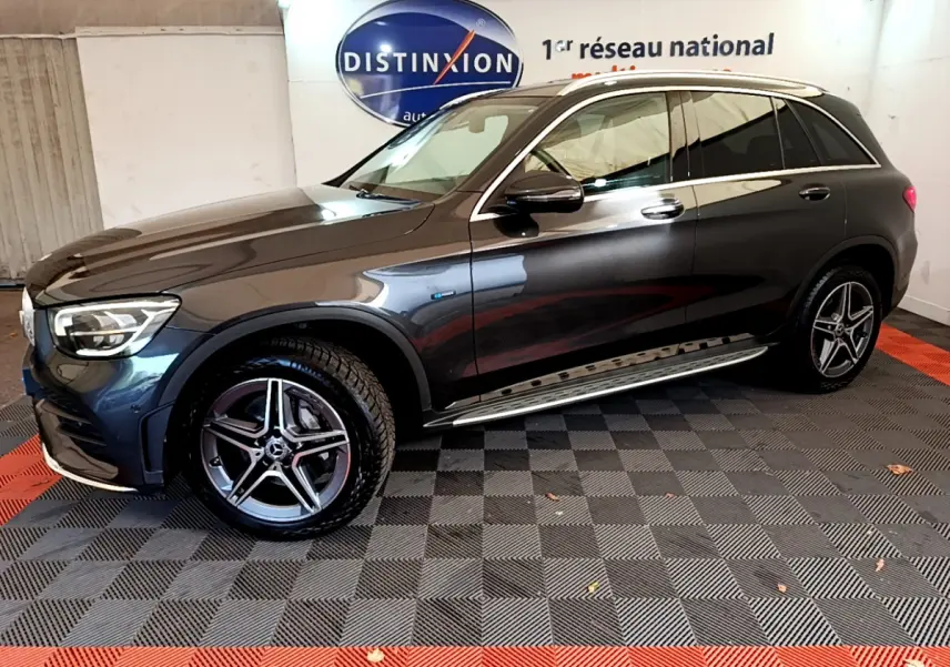 Mercedes GLC 300 E AMG Line gris foncé vu de profil côté gauche, avec jantes AMG et marchepieds chromés.