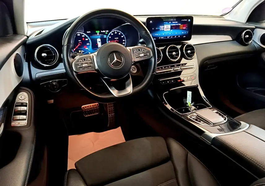 Intérieur Mercedes GLC 300 E AMG Line 2021 vu côté conducteur, tableau de bord moderne avec écran tactile et volant cuir.