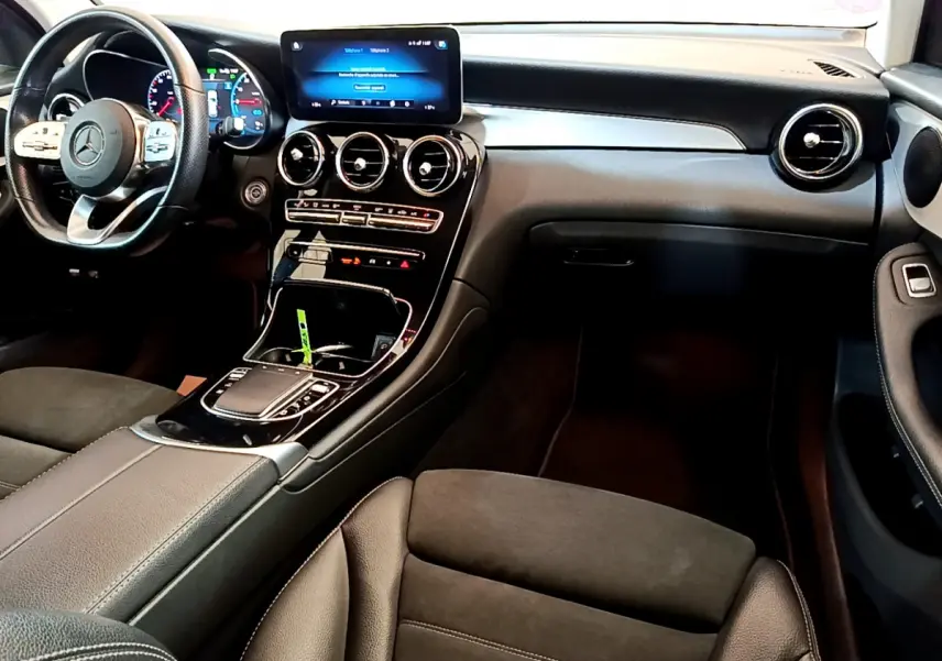 Intérieur du Mercedes GLC 300 E AMG Line 2021, vue côté conducteur sur tableau de bord et console centrale noire élégante.