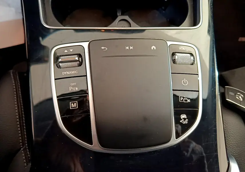 Gros plan sur la console centrale noire brillante du Mercedes GLC 300 E AMG Line 2021 avec commandes tactiles et molette volume.