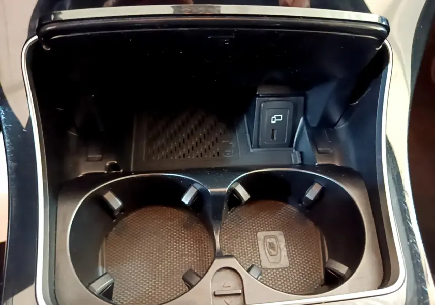 Gros plan sur les porte-gobelets et prise USB dans la console centrale du Mercedes GLC 300 E AMG Line gris foncé.
