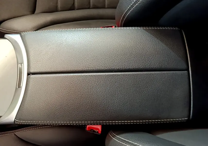 Accoudoir central en cuir noir avec surpiqûres blanches dans l'habitacle du Mercedes GLC 300 E AMG Line 2021.