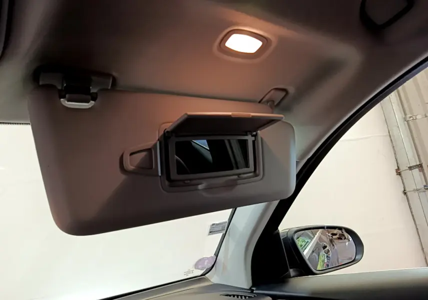 Détail du pare-soleil côté conducteur avec miroir éclairé dans l'habitacle gris clair du Mercedes GLC 300 E AMG Line.
