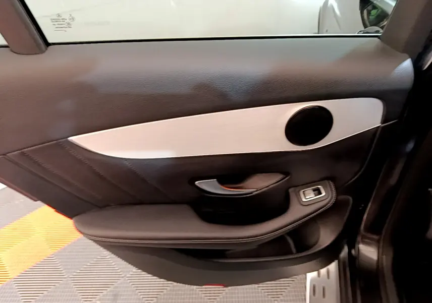 Gros plan sur la porte côté gauche du Mercedes GLC gris foncé, avec garniture noire et insert argenté mat.