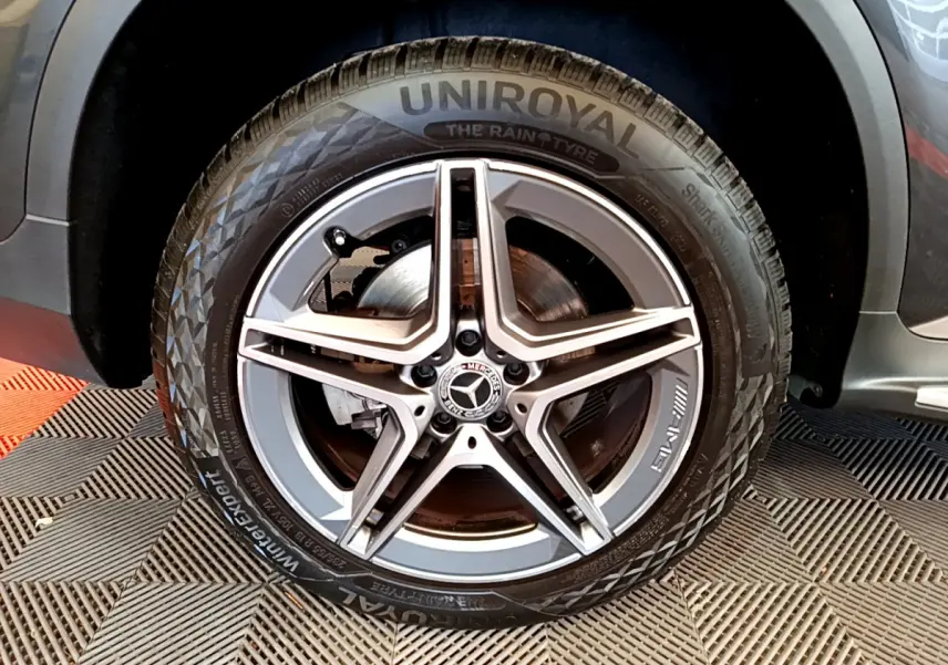 Gros plan sur la roue AMG avec jante étoile grise du Mercedes GLC 300 E hybride gris foncé, côté gauche visible.