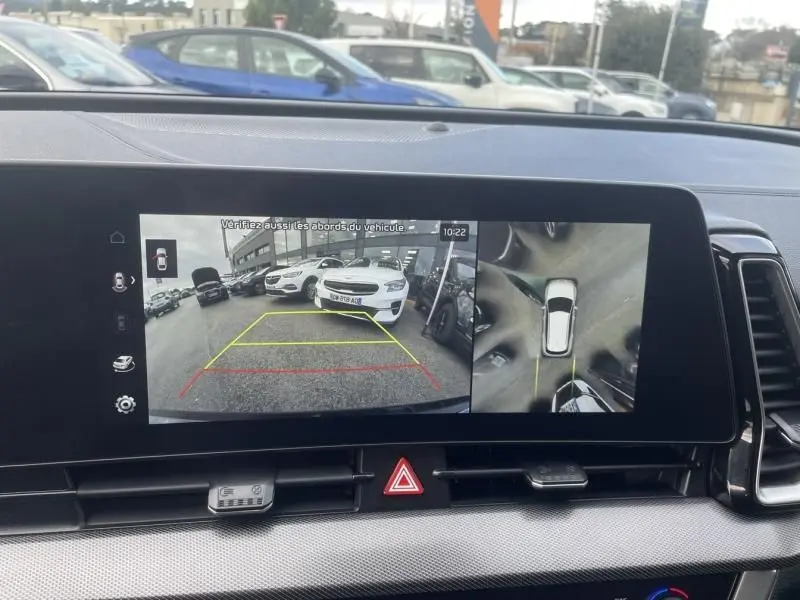 Affichage de la caméra de recul et vue 360° sur l’écran du Kia Sportage 2022 vert métal, avec repères de stationnement visibles.