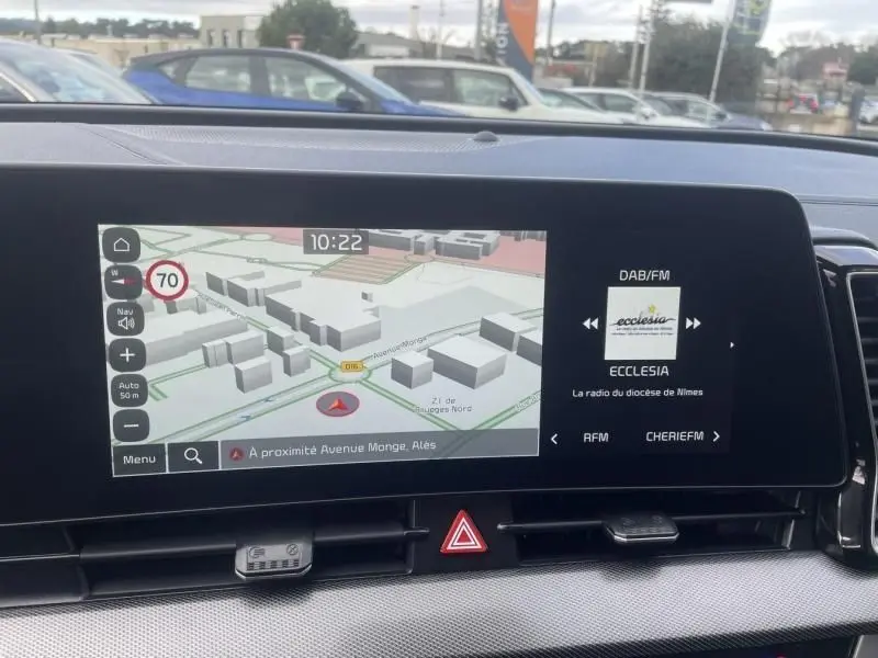 Écran central du Kia Sportage 2022 montrant la navigation 3D et la radio DAB/FM, intérieur moderne et épuré.