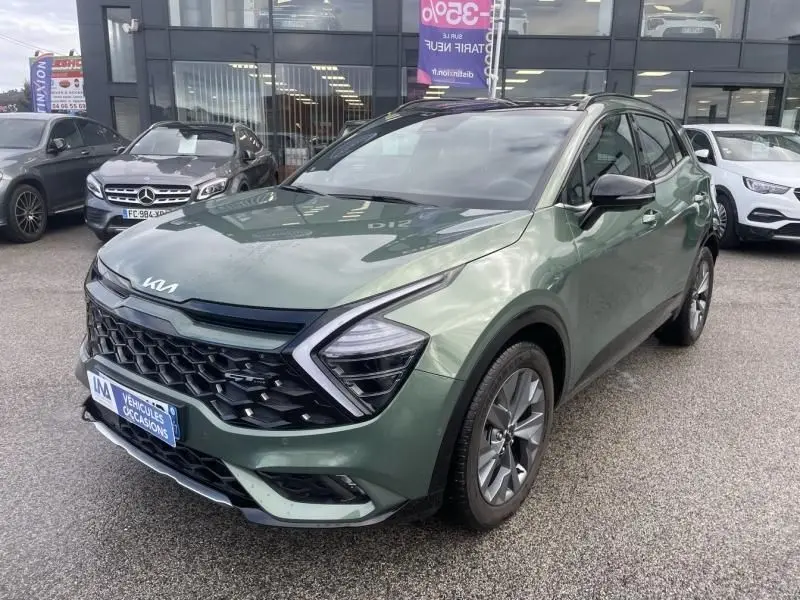 KIA SPORTAGE 2022 vert métal, vue 3/4 avant droit, avec calandre noire distinctive et feux LED angulaires.