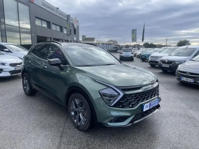 KIA SPORTAGE 2022 vert métal en vue 3/4 avant droit, avec calandre noire et feux LED en forme de flèche.
