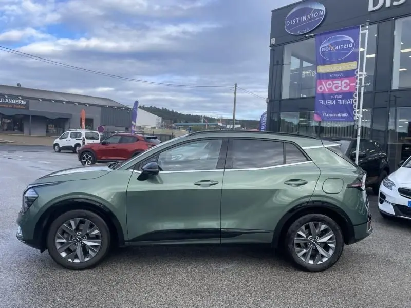 Vue de profil côté gauche du KIA SPORTAGE 2022 vert métal, soulignant ses jantes alliage et lignes modernes.