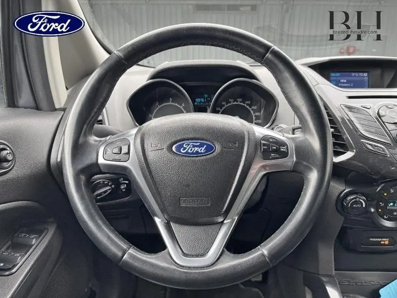 Vue rapprochée du volant cuir multifonction noir du Ford EcoSport 1.5 TDCi 2017 avec tableau de bord et commandes visibles.