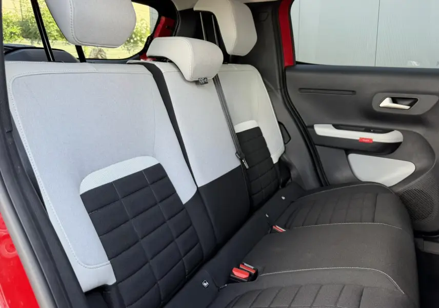 Vue intérieure côté droit des sièges arrière bicolores gris clair et noir d'une Citroën C3 Rouge Elixir.