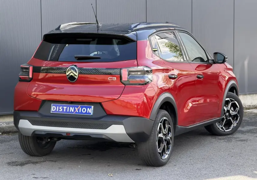 Vue 3/4 arrière droite d'une Citroën C3 Rouge Elixir avec toit noir et jantes alliage 17 pouces.