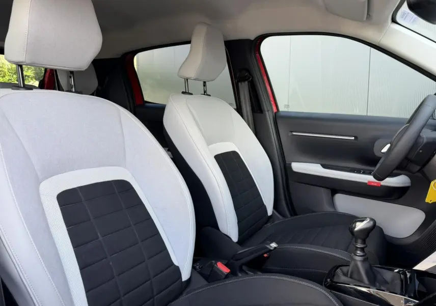 Vue intérieure côté droit des sièges avant gris clair et noir d'une Citroën C3 Rouge Elixir avec boîte manuelle.