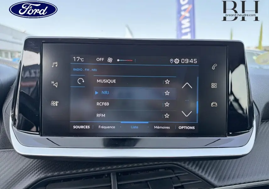 Écran tactile central du tableau de bord d'une Peugeot 208 1.5 BlueHDi, affichant les options radio FM.