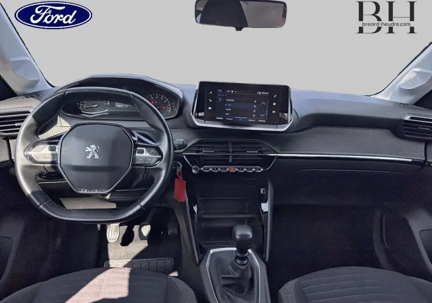 Vue intérieure avant du tableau de bord et volant noir d'une Peugeot 208 1.5 BlueHDi 2020 avec boîte manuelle.