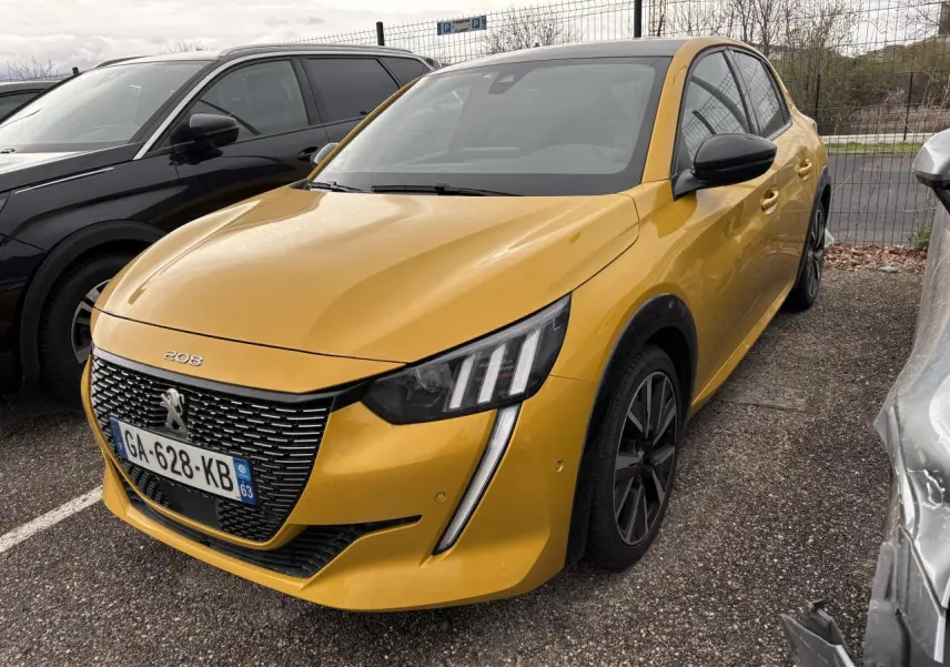 Peugeot 208 GT jaune vue 3/4 avant droit, avec calandre noire et feux LED distinctifs, stationnée en extérieur.