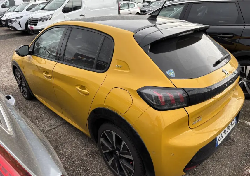 Peugeot 208 GT jaune vue 3/4 arrière droit, toit noir et feux arrière à griffes distinctifs.