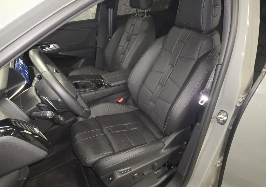 Vue intérieure côté conducteur du DS7 Crossback 2025 gris, avec sièges avant en cuir noir et volant multifonction.