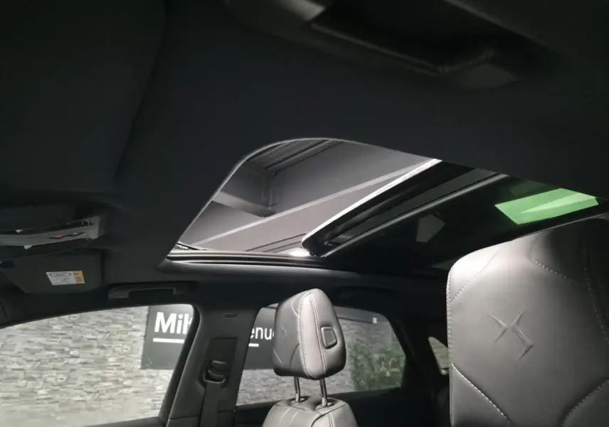 Vue intérieure du toit ouvrant panoramique et des appuie-têtes en cuir gris du DS7 Crossback 2025.
