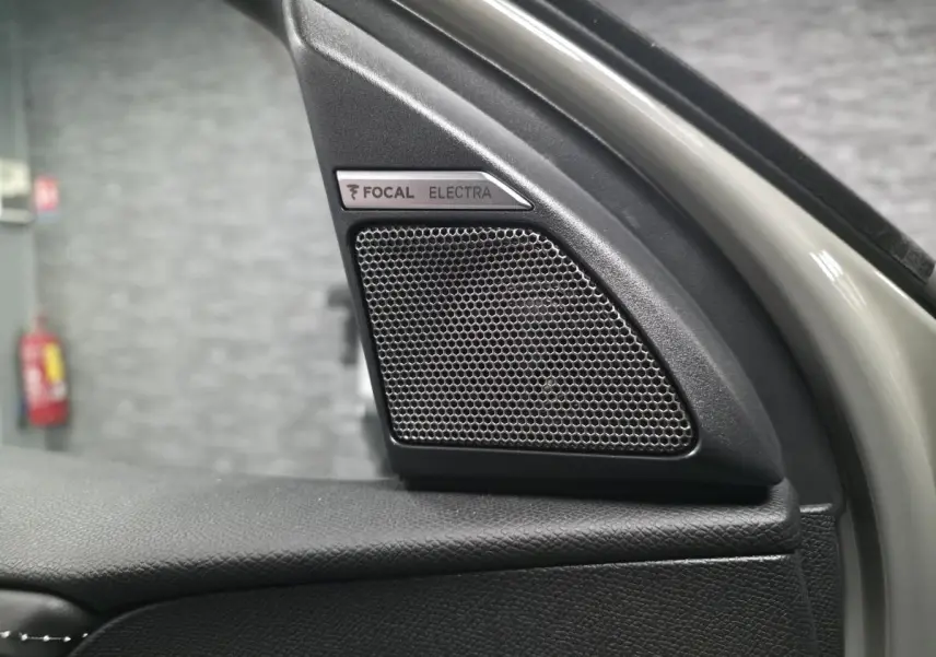 Gros plan sur le haut de la porte avant gauche du DS7 Crossback gris, mettant en valeur l'enceinte FOCAL Electra intégrée.