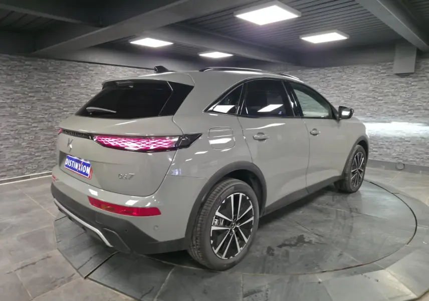 DS7 Crossback gris en 3/4 arrière droit, avec feux arrière LED 3D et jantes alliage noires brillantes.