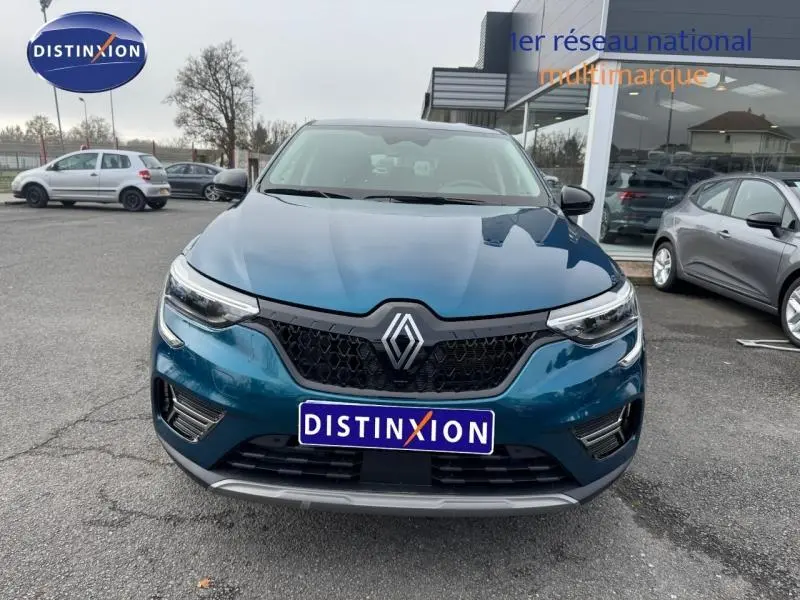 Vue avant d'un Renault Arkana 2025 bleu Zanzibar avec calandre noire et logo Renault bien visible.