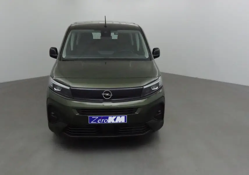 Vue frontale d'un Opel Combo Life vert Sirkka avec calandre noire et phares LED allumés dans un studio gris.