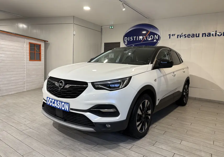 Opel Grandland X blanc en 3/4 avant droit, SUV hybride rechargeable avec jantes noires et toit noir contrasté.