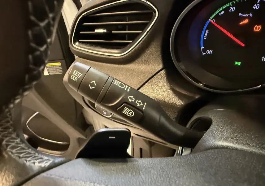 Gros plan sur la manette de clignotant et le tableau de bord du côté gauche d’un Opel Grandland X blanc hybride rechargeable.