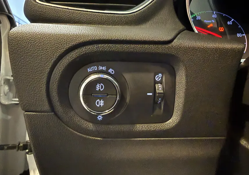 Détail du tableau de bord noir de l'Opel Grandland X 2021 montrant les commandes d'éclairage et réglage de luminosité.