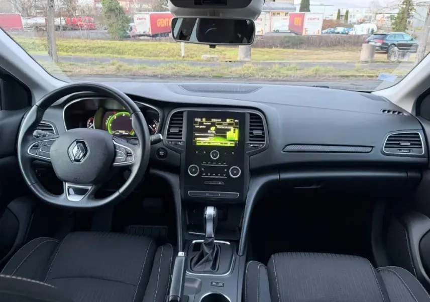 Vue intérieure avant de la Renault Mégane 1.5 BlueDCI 2019, tableau de bord noir avec écran central tactile et volant multifonction.