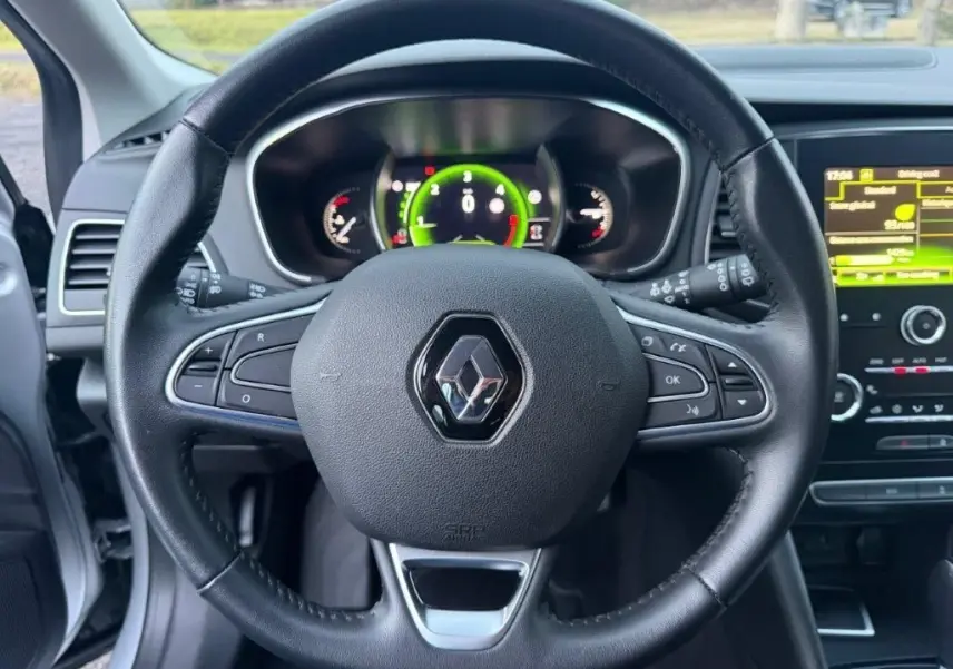 Vue centrée sur le volant noir de la Renault Mégane 2019 avec tableau de bord numérique et écran tactile à droite.