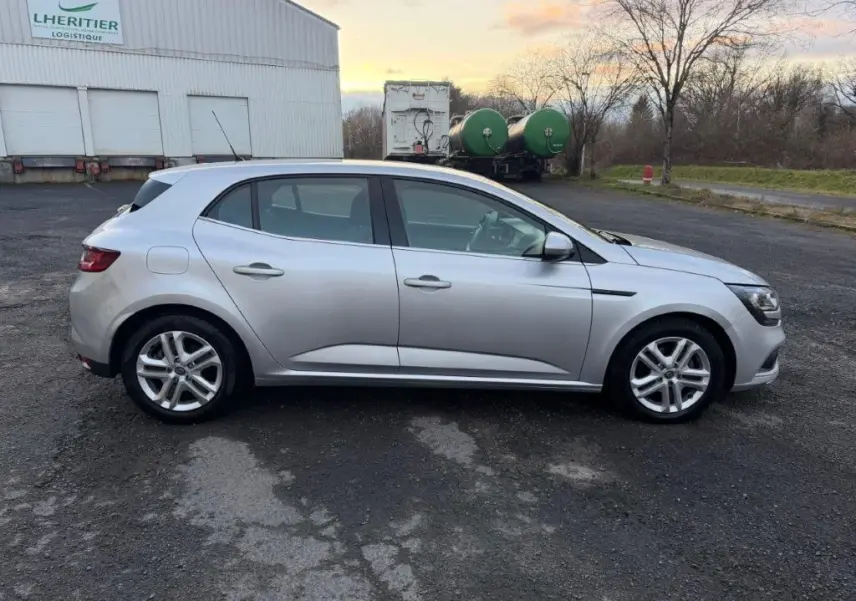 Vue de profil côté gauche d'une Renault Mégane gris alu 2019, avec jantes alliage et lignes épurées.