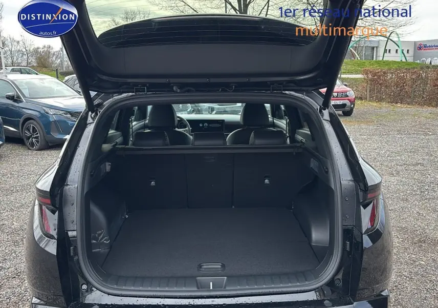 Vue arrière du coffre ouvert d'un Hyundai Tucson noir 2026, intérieur spacieux et banquette rabattable visible.