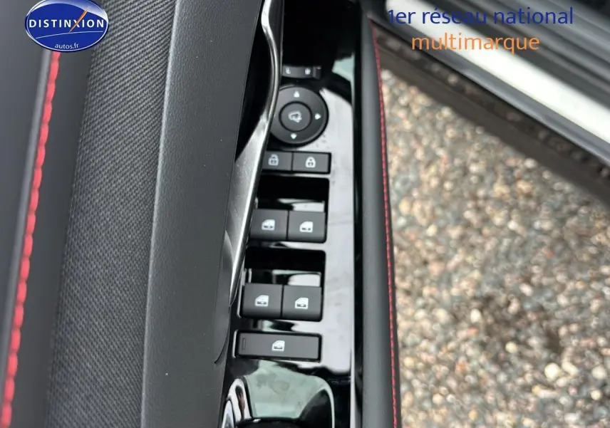 Détail de la porte côté conducteur du Hyundai Tucson noir 2026, avec commandes de vitres et surpiqûres rouges.