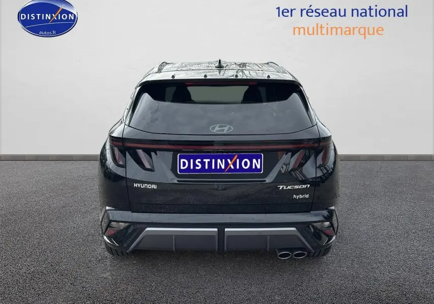 Vue arrière d'un Hyundai Tucson noir hybride 2026 avec feux LED et double sortie d'échappement côté droit.