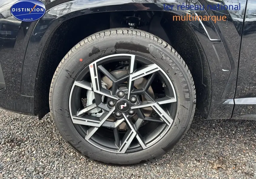 Gros plan sur la jante alliage 19 pouces noire et argent du côté avant gauche du Hyundai Tucson noir 2026.