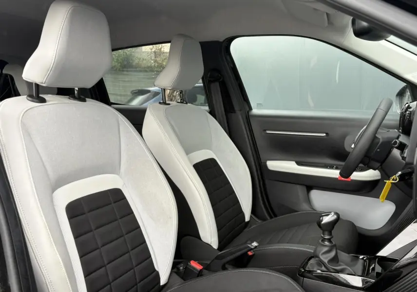 Vue intérieure côté gauche montrant les sièges bicolores gris clair et noir de la Citroën C3 Turbo 100 Max 2025.