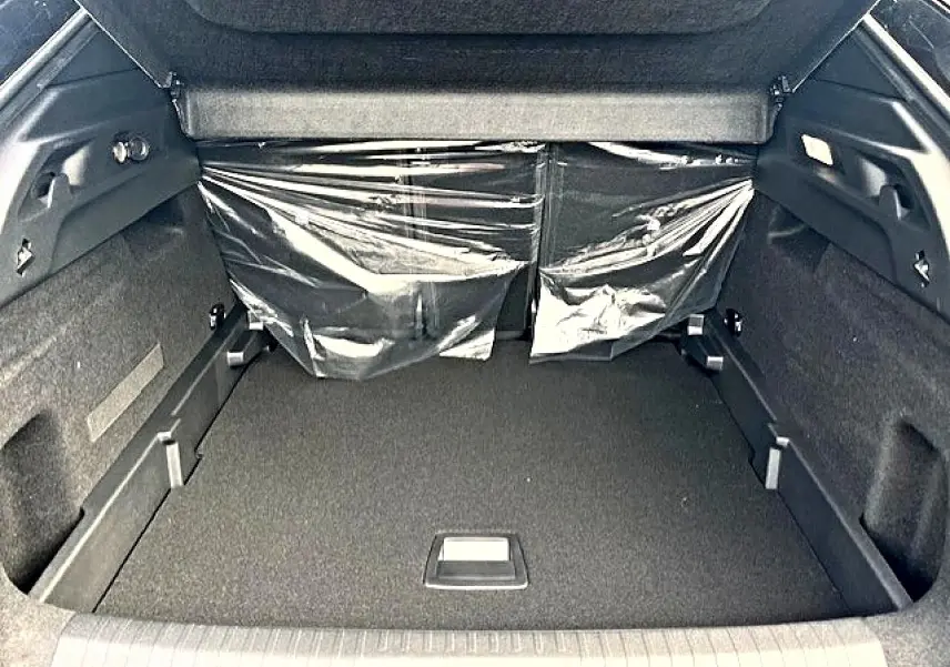 Coffre ouvert du Peugeot 3008 gris titane, vue de l'arrière montrant un espace de rangement propre et spacieux.