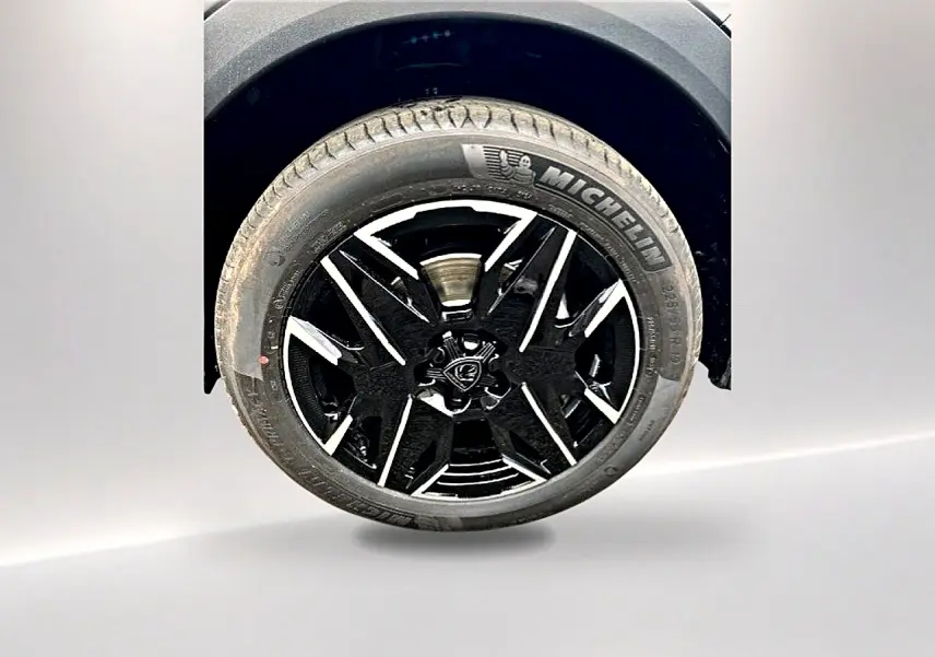 Gros plan sur la roue avant droite du Peugeot 3008 gris titane, jante alu noire et argentée avec pneu Michelin.