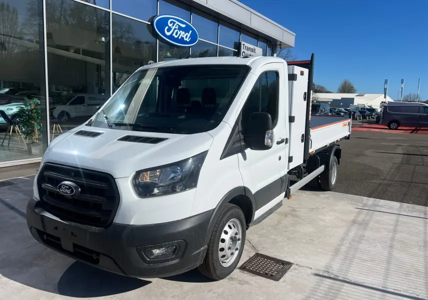 Ford Transit Chassis Cabine blanc vu 3/4 avant droit avec benne relevée et coffre latéral acier.