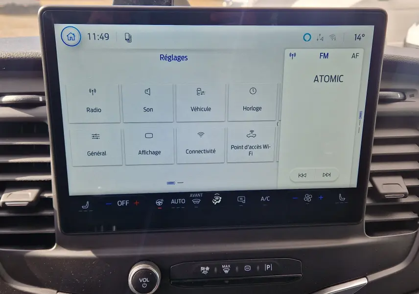 Écran tactile central du Ford Transit Chassis Cabine blanc, affichant le menu Réglages et la radio FM.