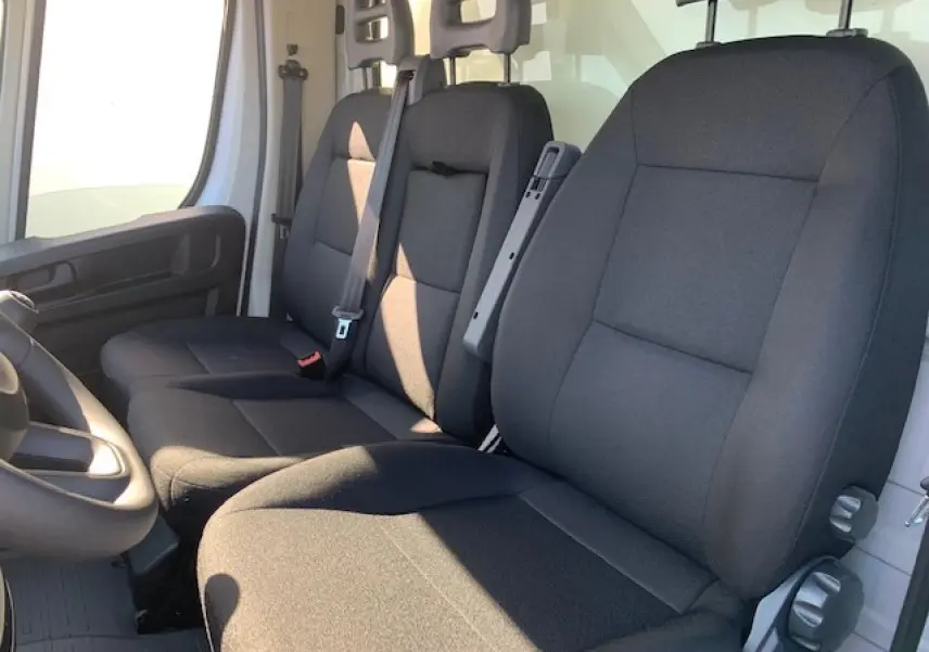 Vue intérieure côté conducteur du Fiat Ducato Fourgon 2022, montrant la banquette passager biplace noire et le siège conducteur noir.