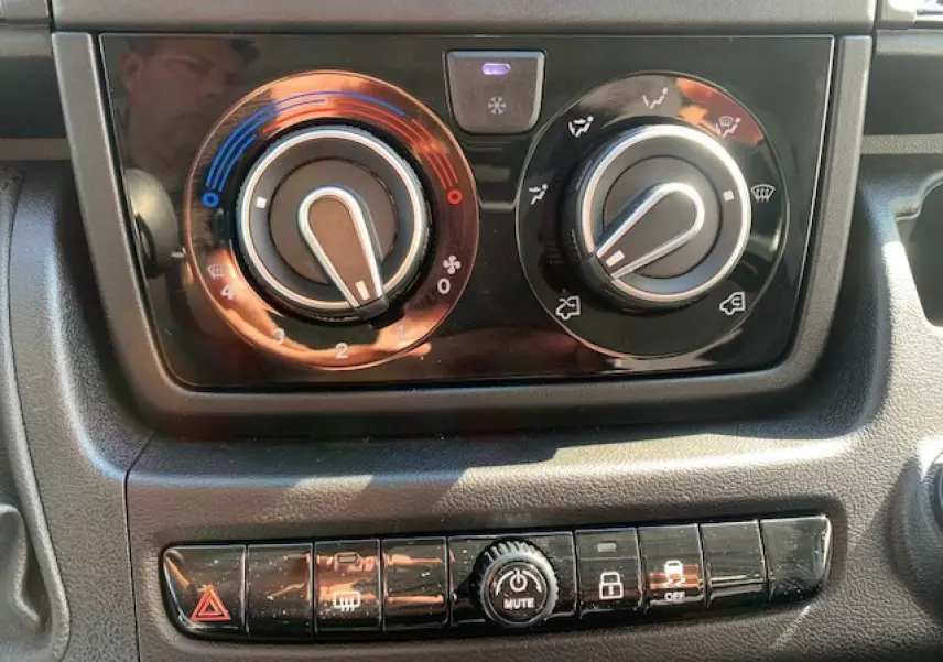 Gros plan sur les commandes de climatisation et les boutons de fonction du tableau de bord du Fiat Ducato Fourgon blanc 2022.