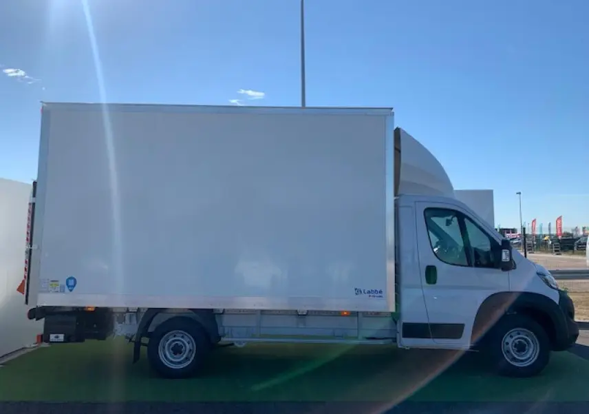 Fiat Ducato Fourgon blanc vu de profil côté gauche, avec caisse fourgon et hayon arrière visible.