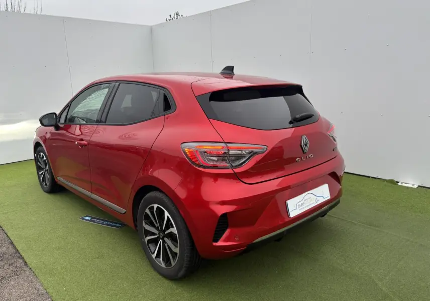 Renault Clio V rouge flamme métal vue 3/4 arrière droit, feux LED et jantes alliage 16 pouces visibles.
