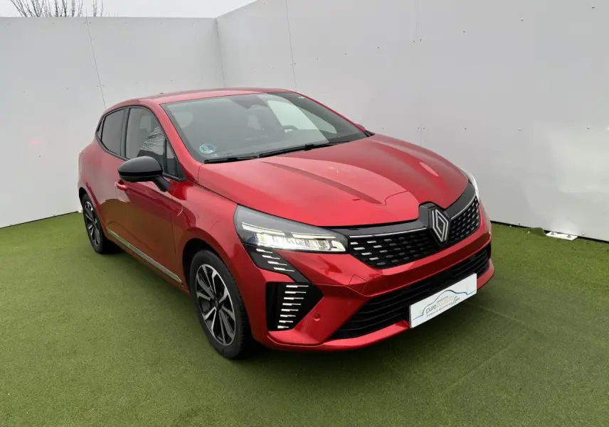 Renault Clio V rouge flamme métal vue 3/4 avant, avec signature lumineuse LED en C et jantes alliage noires.