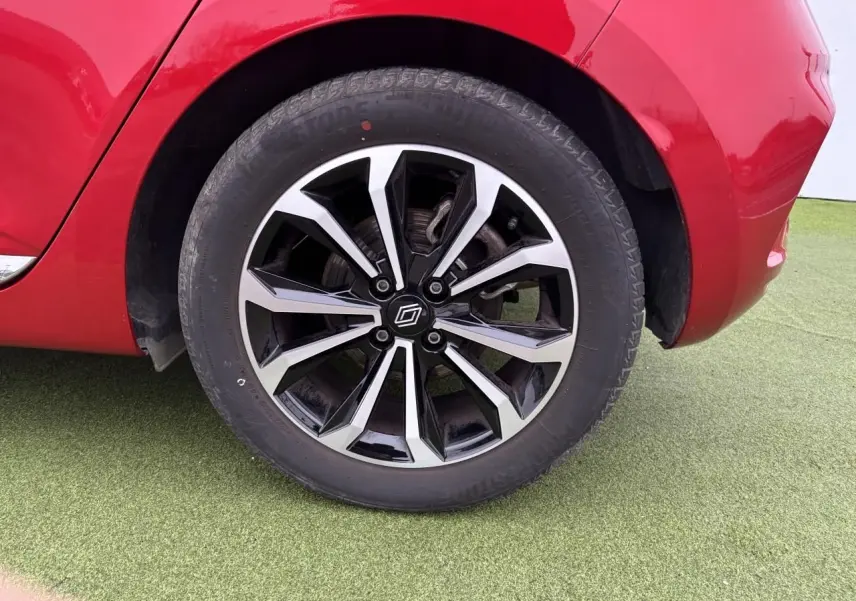 Gros plan sur la roue arrière droite de la Renault Clio V rouge flamme avec jante alliage noire et argentée.