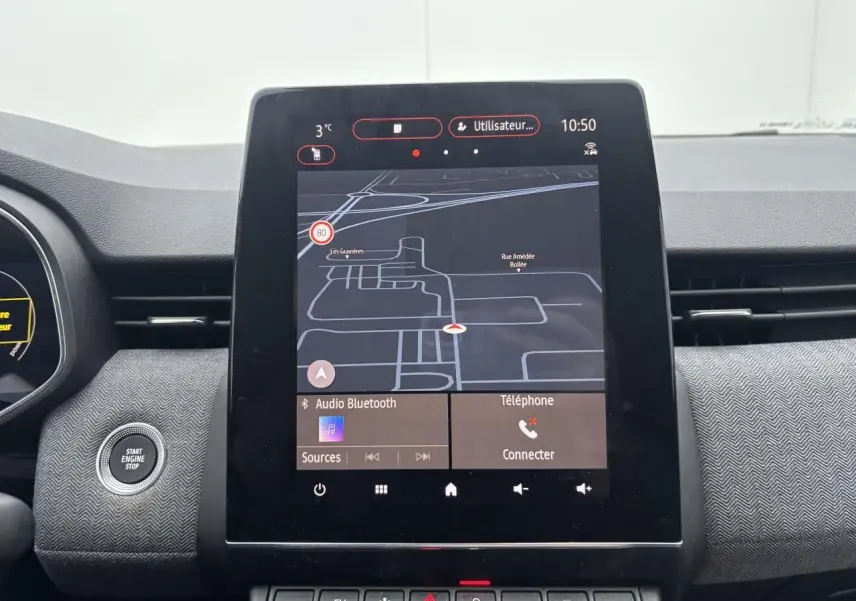 Vue rapprochée de l'écran tactile central du tableau de bord de la Renault Clio V rouge flamme, affichant la navigation GPS.